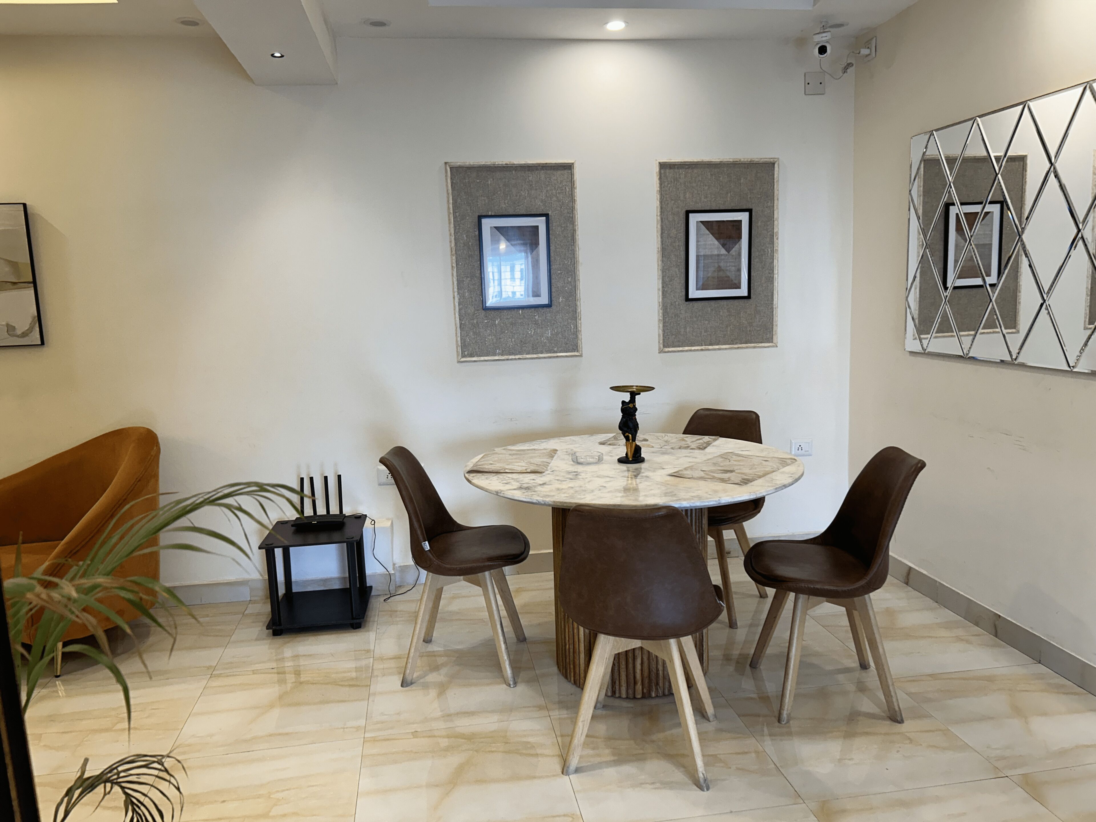 Un comedor con una mesa redonda, seis sillas e imágenes enmarcadas en la pared.