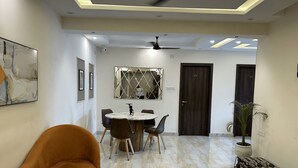 A modern dining area with a round table, chairs, and a ceiling fan. - The Aster Heritage (Kolkata)