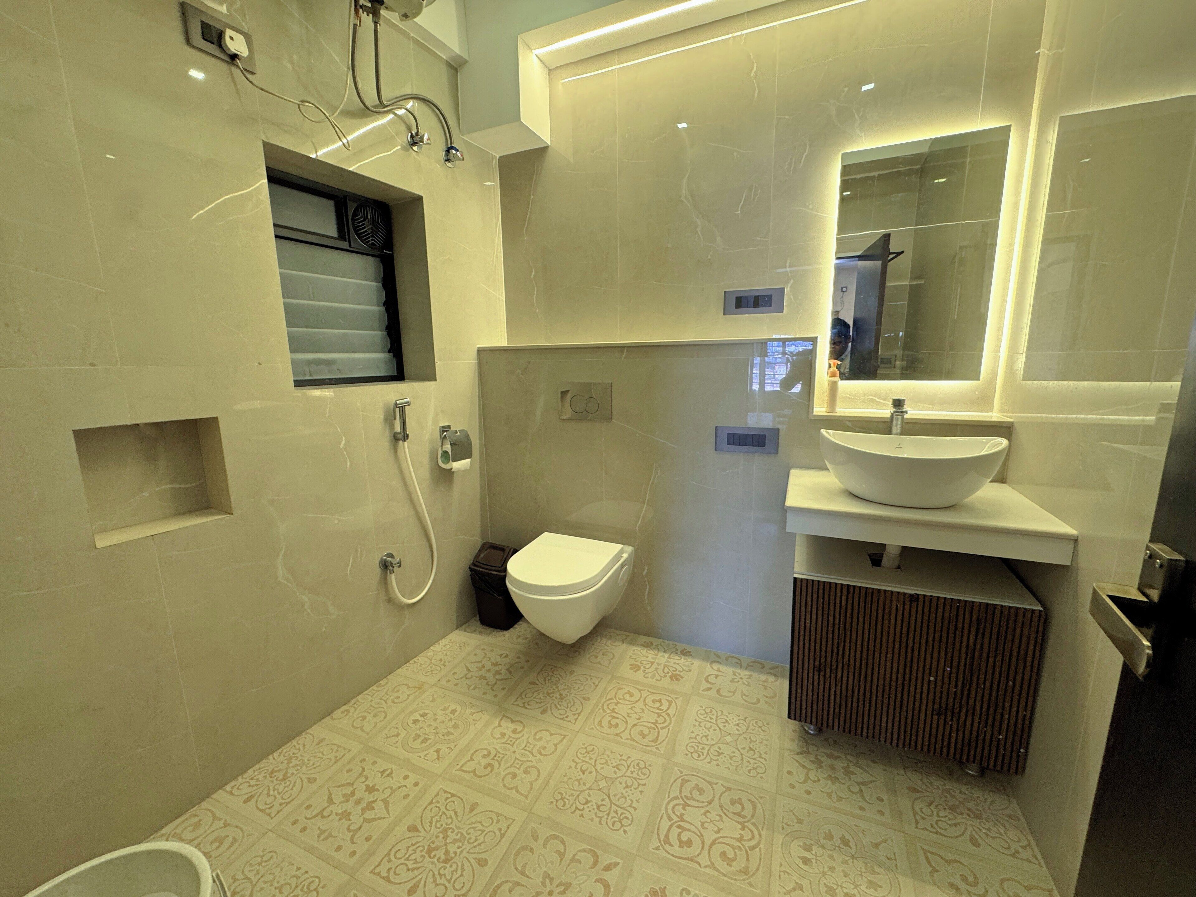 A modern bathroom with a toilet, sink, and shower.