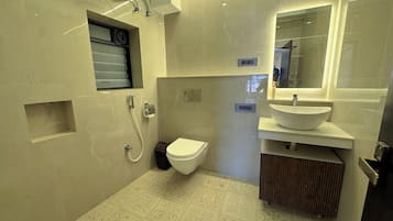 A modern bathroom with a toilet, sink, and shower.