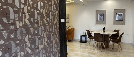 A modern dining area with a large wall of text, a ceiling fan, and framed pictures on the wall.