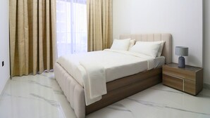 Una camera da letto moderna con un letto, tende, un comodino e una lampada.