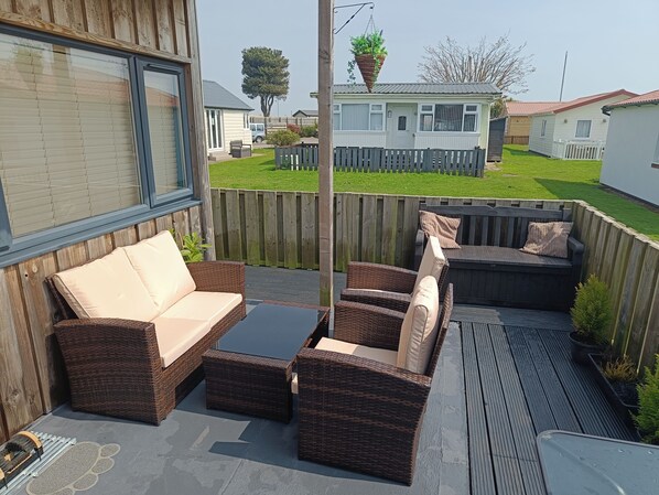 A patio with wicker furniture, a glass door, and a view of a residential area.