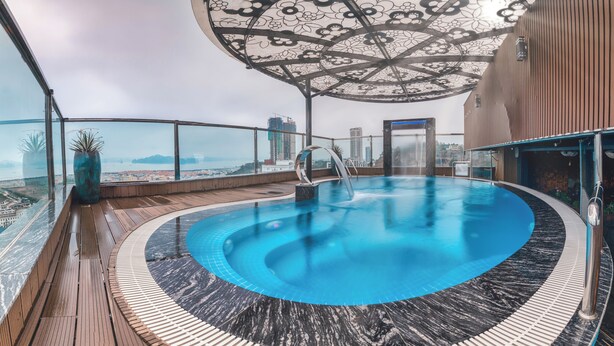An indoor pool with a circular design, surrounded by wooden decking and a patterned floor. - Thai Ha Boutique Hotel (Bai Chay)