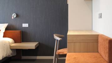 Quarto moderno com cama, um banco, um banquinho e uma estante embutida.