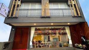 A multi-story building with a modern design, featuring balconies with wooden railings and a glass entrance. - Sun lake Hotel (Yuchi)