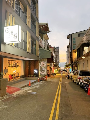 A street view with a hotel on the left, featuring a signboard and a storefront with a chair outside. - Sun lake Hotel (Yuchi)