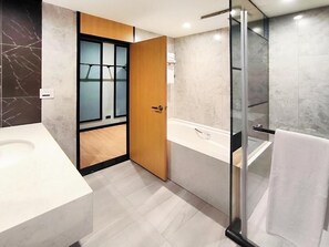 A modern bathroom with a large white sink, a glass shower enclosure, and a wooden door leading to a shower area. - Sun lake Hotel (Yuchi)