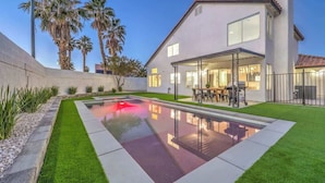 A modern house with a swimming pool, patio, and palm trees. - Entertainment Galore in 4BR Oasis w/ Pool! (North Las Vegas)