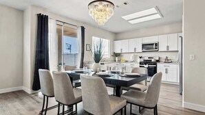 Une cuisine moderne avec des meubles blancs, un four à micro-ondes et une cuisinière.