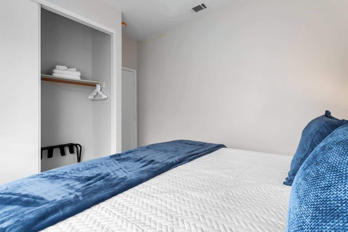 A bedroom with a bed, a wardrobe, and a hanging chair.