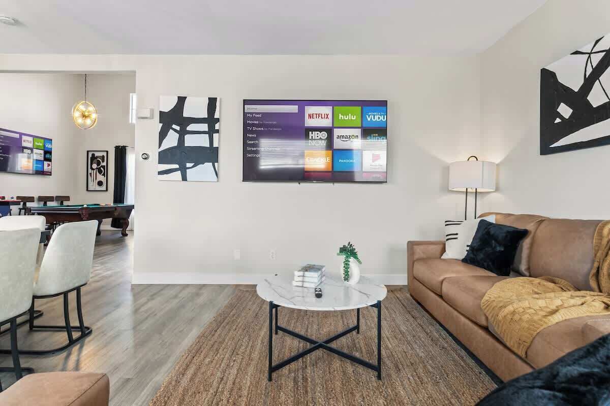 Ein modernes Wohnzimmer mit Billardtisch, einer Couch und einem Couchtisch.