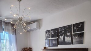 A bedroom with a large bed, a wooden headboard, and a wall-mounted air conditioner.