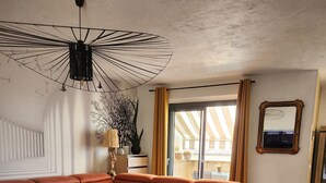 A modern living room with a sectional sofa, a round coffee table, and a ceiling light fixture.