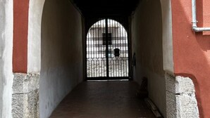 A corridor with a brick floor and an arched entrance leading to a gated area. - Z-y-x- Residence Archive 180 (Cesinali)