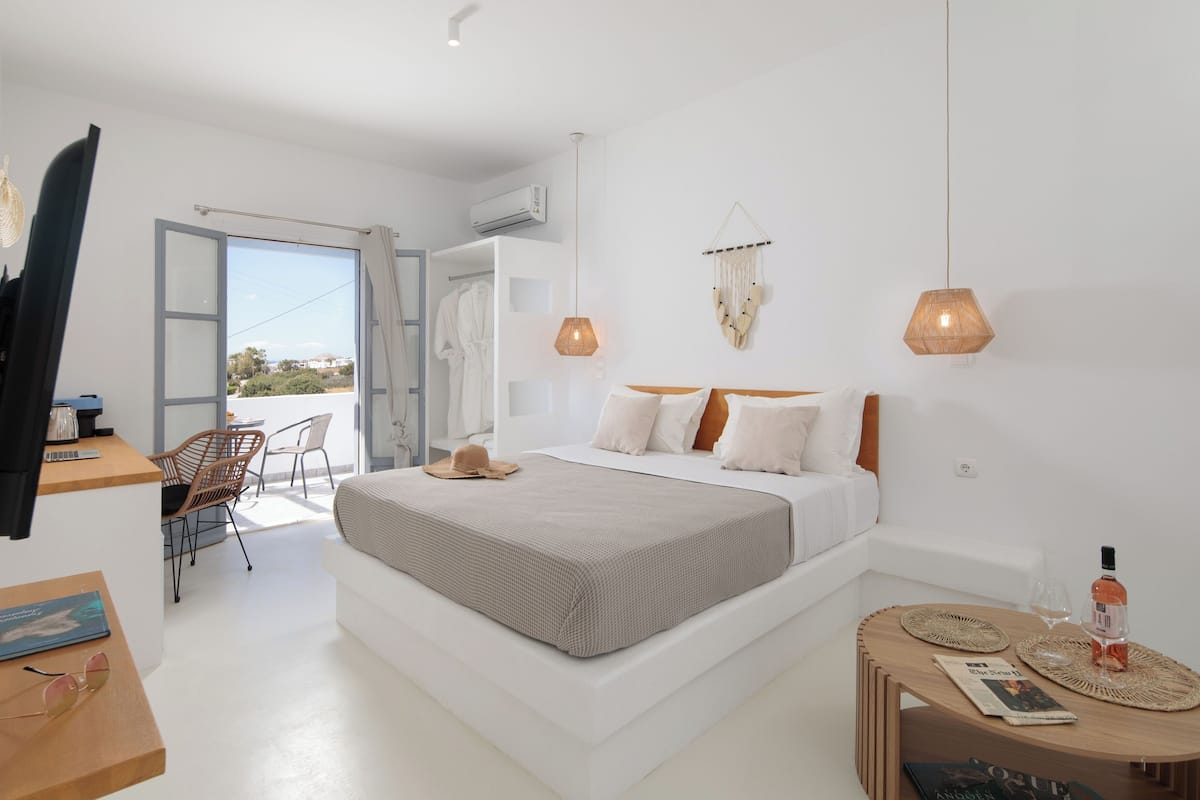 A modern bedroom with a large bed, bedside tables, a desk, and a chair.
