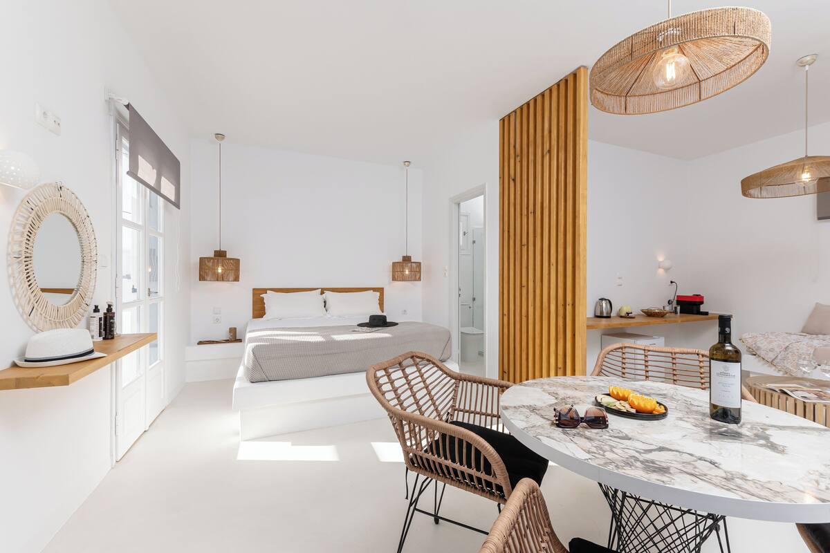 A modern bedroom with a bed, bedside tables, and a large window.