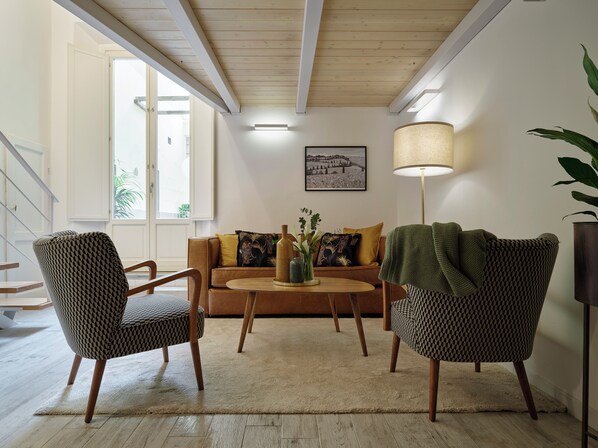 A living room with a sofa, two patterned armchairs, a coffee table, and a floor lamp. - Vintage Romance Patio Apt by Oteego (Florence)