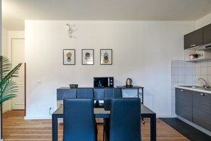 A modern kitchen with a dining area, featuring a microwave, kettle, and a small table with chairs. - Moretto 11. with pool and WiFi (Sirmione)