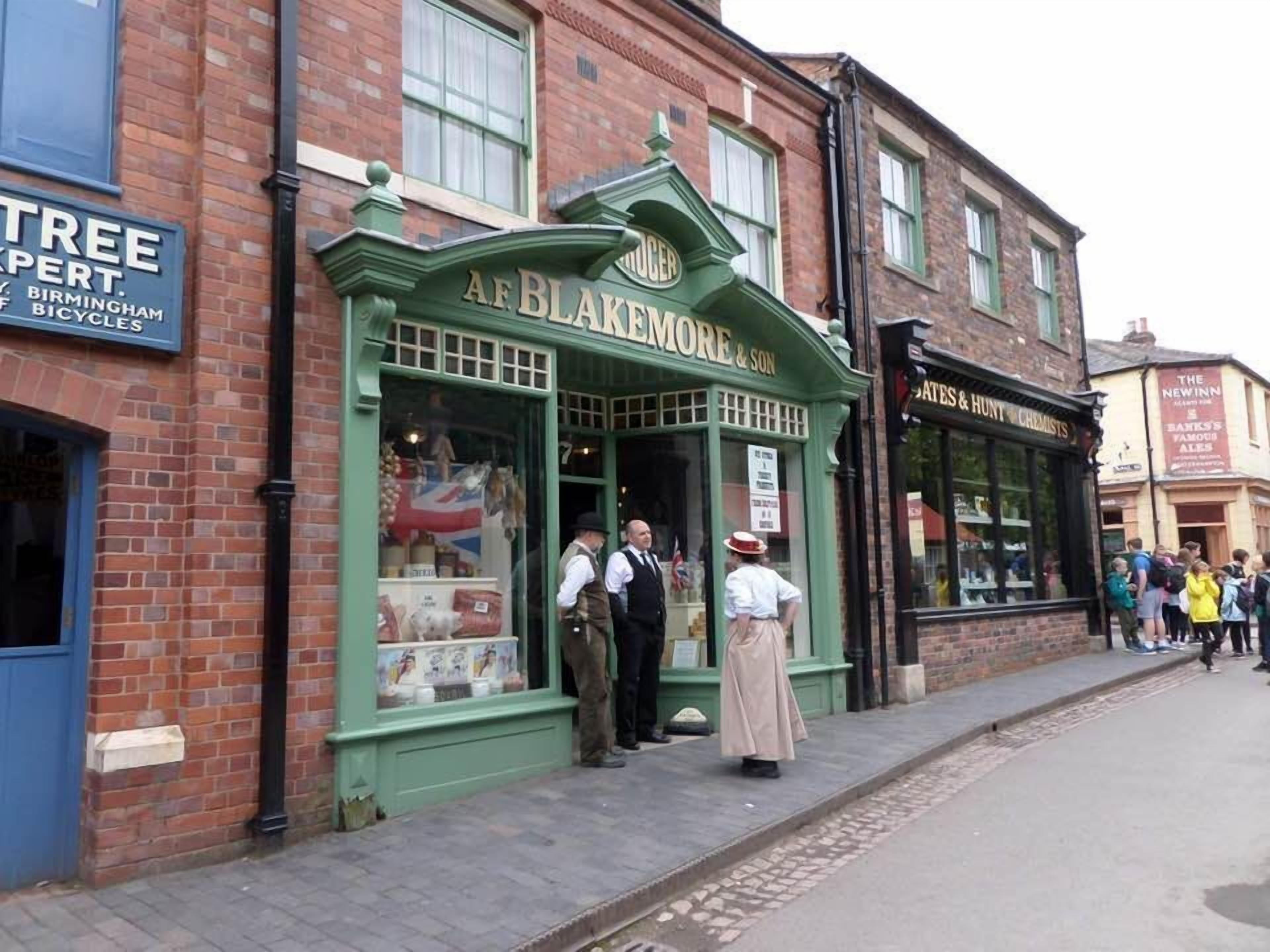 A traditional British pub named "AF Blakemore & Son" with a green facade and a signboard.