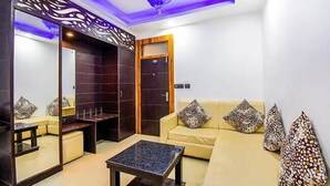 A modern living room with a sofa, a coffee table, and decorative pillows. - Hotel City Pride (Haridwar)
