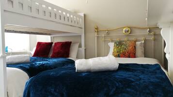 A double bed with a headboard, two pillows, a blanket, and a window with a view.