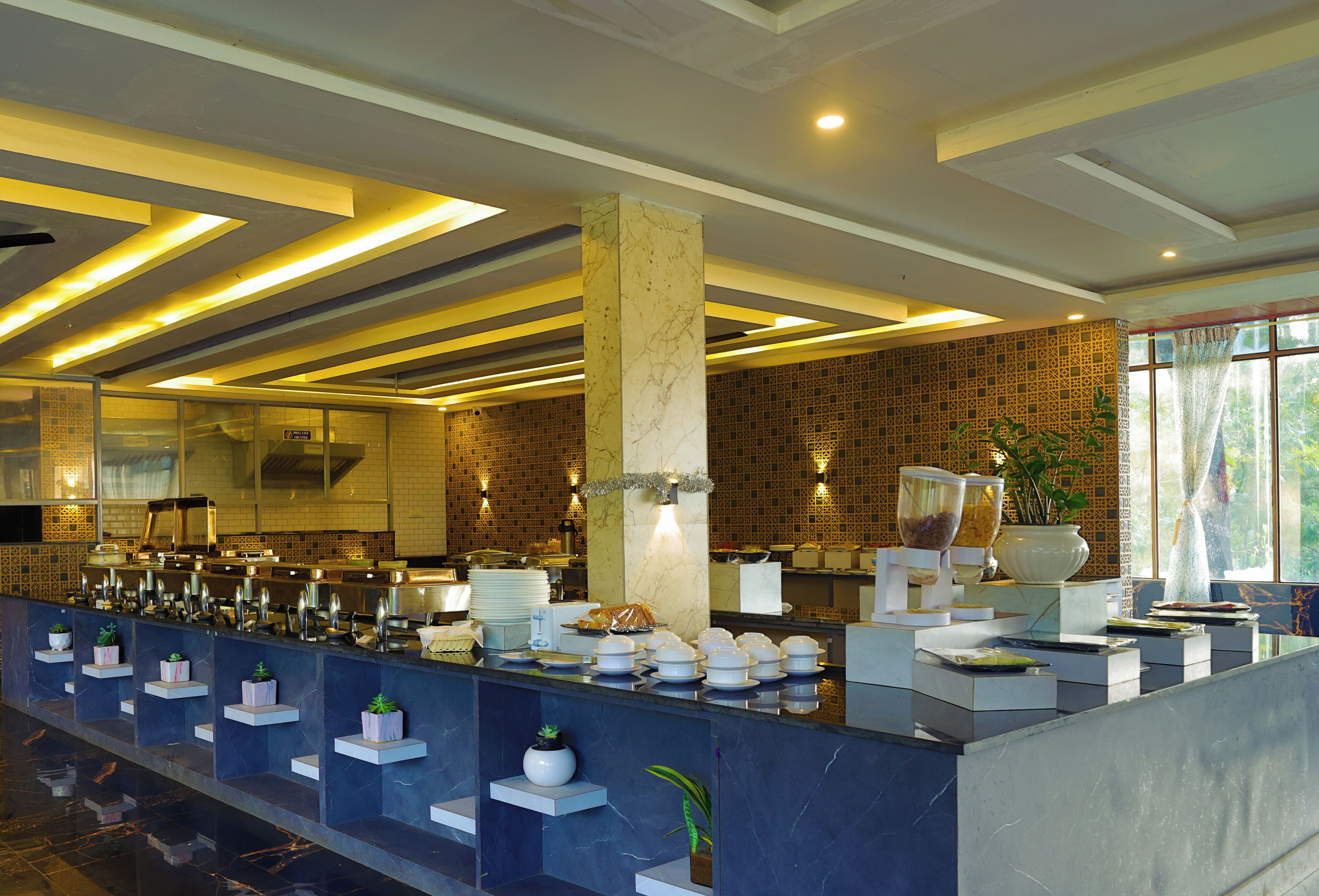 A modern hotel lobby with a long reception counter, marble columns, and a patterned wall.