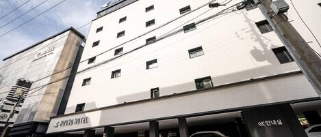A multi-story building with a sign reading 'HOUND HOTEL' on the facade.