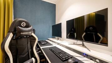 Uma cadeira gamer com a marca 'GAMING TITAN', configuração de dois monitores, teclado e mouse em uma mesa.