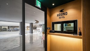 En receptionsdisk på Hound Hotel med træbeklædning og et skilt over disken.