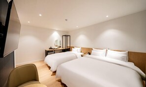 Una habitación de hotel con dos camas, un escritorio, una silla y un televisor.