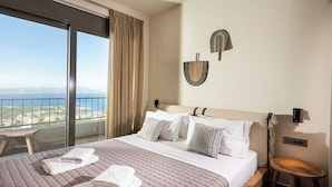 Una habitación de hotel con una cama grande, vista al mar y un balcón.