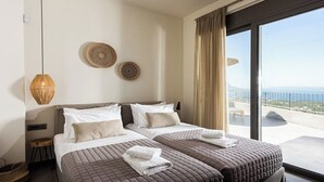Habitación de hotel con dos camas, un ventanal con vistas y decoración en la pared.