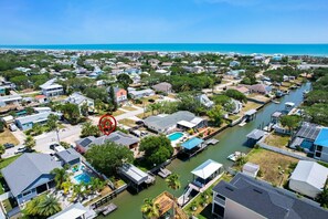 A residential area with houses, a river, and a beach in the background.