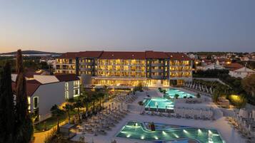 Enjoy a family-friendly stay with a pool and play area, surrounded by lush greenery and a scenic town view.