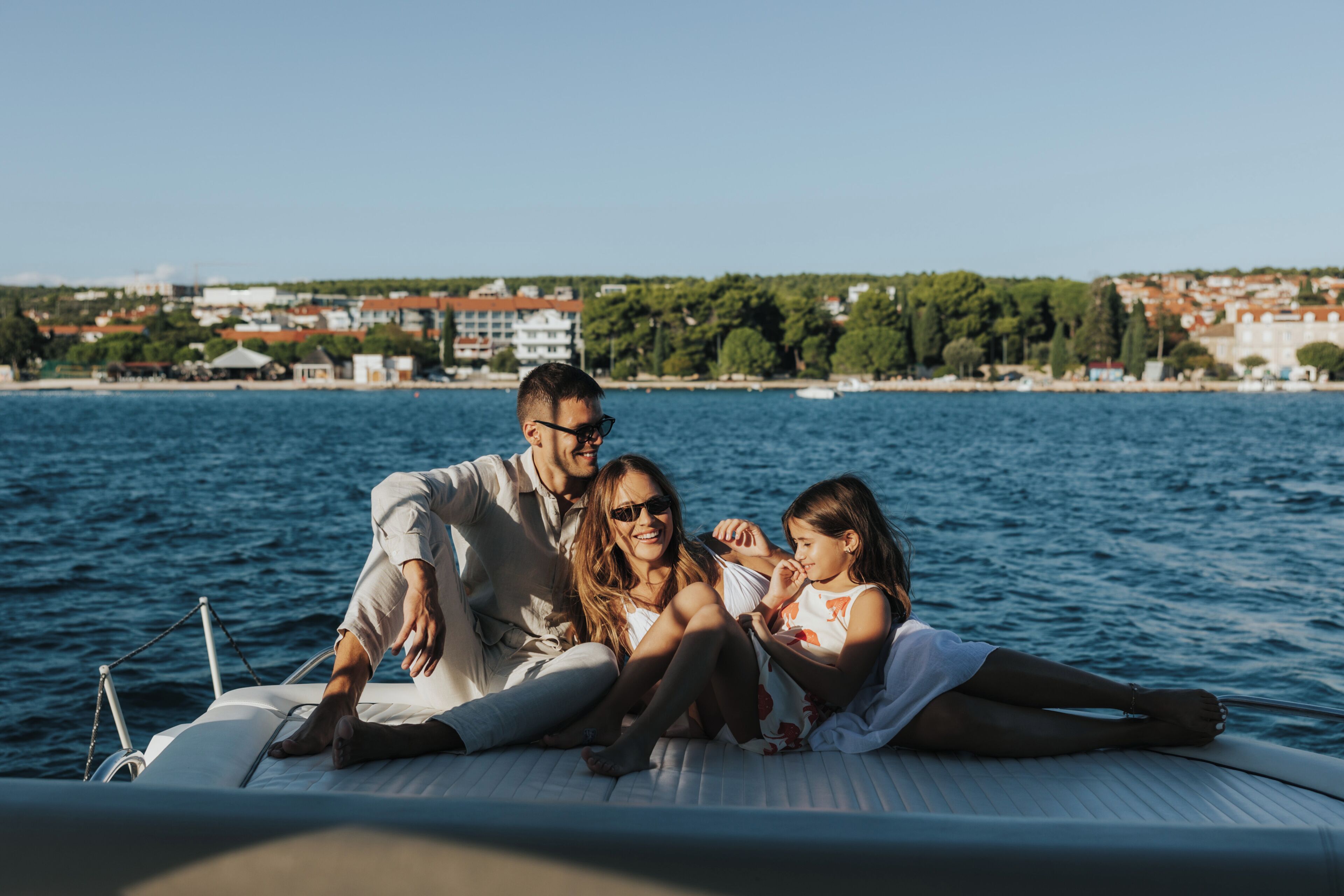 Eine Familie auf einem Boot mit Blick auf eine Küstenstadt.