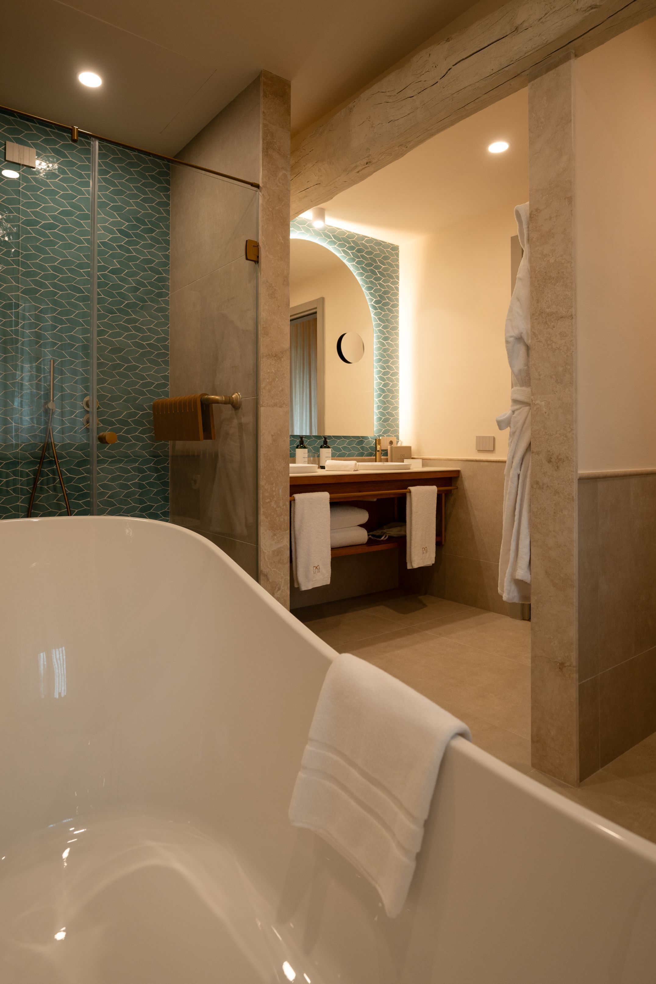 A modern bathroom with a freestanding bathtub, a glass shower enclosure, and a vanity with a mirror and sink.