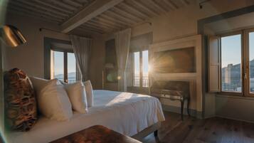 Un dormitorio con cama, escritorio y vista al exterior.