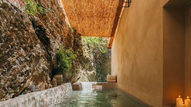 A spa area with a rock wall, a small waterfall, and candles. - La Monastica Resort & Spa (Buggiano)