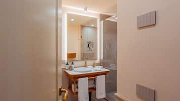 Un bagno moderno con lavabo doppio, un ampio specchio e cabina doccia in vetro.