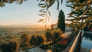 A poolside area with a view of a cityscape and mountains in the distance. - La Monastica Resort & Spa (Buggiano)