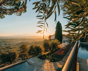 Una piscina al aire libre, sombrillas, sillones reclinables de piscina