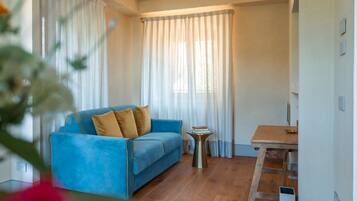 A room with a blue sofa, a small table, and a ladder against the wall.