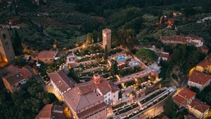 An aerial view of a historic town with a prominent tower, terraced gardens, and traditional architecture. - La Monastica Resort & Spa (Buggiano)