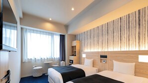 Habitación de hotel con dos camas, una televisión de pantalla plana, una mesita redonda pequeña, un sofá y una pared decorativa de madera.