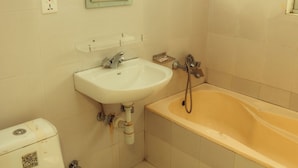 A bathroom with a toilet, sink, and bathtub. - Hotel Gantabya Inn (Pokhara)