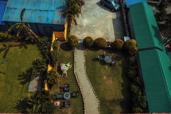 An aerial view of a courtyard with a paved walkway, seating area, and a small pool. - Hotel Gantabya Inn (Pokhara)