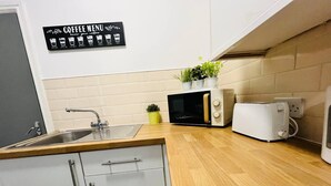 Eine Küche mit Spüle, Mikrowelle, Toaster und einer Kaffeeschild.