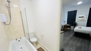 Ein modernes Badezimmer mit Badewanne, Toilette und Dusche.