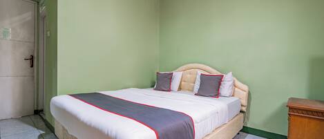A neatly made bed with a white and grey bedspread, a wooden headboard, and two pillows.